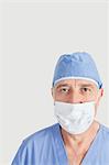 Porträt des leitenden Chirurgen mit der chirurgischen und Maske über den grauen Hintergrund