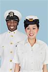Portrait des officiers de marine américaine multiethniques souriant sur fond bleu clair