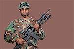 Portrait d'un soldat afro-américain US Marine Corps tenant un fusil d'assaut M4 sur fond marron
