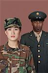 Portrait of young, female soldier with male officer in background