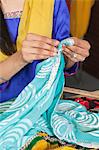 Midsection of dressmaker working on a sari