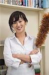 Portrait of female housekeeper holding feather duster