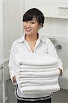 Porträt des wunderschönen Hausmädchen halten weiße Handtücher