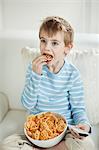 Junge vor dem Fernseher während des Essens Rad Form Snack-pellets