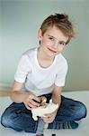 Portrait of young boy putting coin in piggy bank