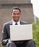 Portrait of a happy African American businessman using laptop