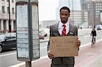 Jeune homme tenant affiche du « Travail contre nourriture Will » à l'adresse