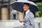 Glücklich Afroamerikaner Unternehmer holding Regenschirm