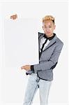 Portrait of a young man holding blank cardboard over gray background