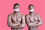 Portrait de deux hommes afro-américains musculaires avec rubans couvrant la bouche sur fond rose