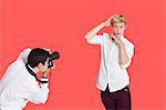 Male actor being photographed by paparazzi over red background