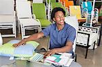 Male African American salesperson working in garden furniture store