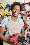 Portrait of an African American male store clerk holding electronic tool