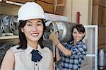 Portrait de femme souriant avec travailleuse industrielle portant la bouteille de propane en arrière-plan