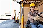 Female industrial worker driving forklift truck