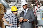 Weibliche Industriearbeiter und männlichen Ingenieur in Diskussion am Holz Fabrik