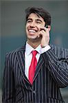 Happy Indian businessman communicating on cell phone