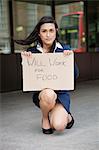 Young Indian businesswoman holding 'Will Work for Food' sign