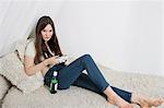 Beautiful young woman having beer while playing video game