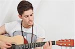 Young Caucasian man playing guitar