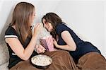 Joyeuses jeunes femmes manger le pop-corn dans le lit