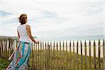 Woman Leaning on Sandfence am Strand, Camaret-Sur-Mer, Halbinsel Crozon, Finistere, Bretagne, Frankreich