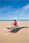 Frau mit Tablet am Strand, Camaret-Sur-Mer, Halbinsel Crozon, Finistere, Bretagne, Frankreich