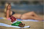 Nain de jardin sur la plage regardant femme
