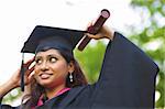 Jeune asiatique indienne étudiante ajustant son chapeau de diplômé