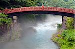 Red sacred bridge Shinkyo in Nikko, Japan and a mist rising from the river