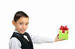 smiling boy in black suit holding green gift box with red bow isolated on white background