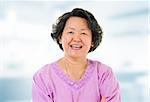 60s cheerful Asian senior woman smiling in home