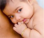 Six months old Indian baby girl is lying on daddy chest