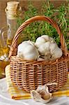 Garlic in a wicker basket on a kitchen board.