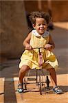 Happy girl riding a centenarian toy tricycle