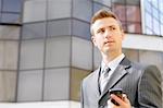 businessman holds the phone on the building background