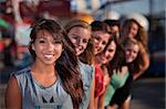 Mixed row of eight smiling girls outside together