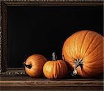 Different sized pumpkins on table with menu board in back