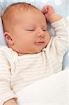 Happy Smiling Newborn Baby in the Bed