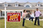 Sold Real Estate Sign and Playful Hispanic Family in Front of House.