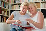 Family happiness and memories, happy mom and daughter looking at pictures in photo album