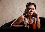 Beautiful serious European brunette female with coffee mug