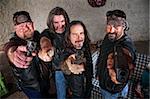 Smiling group of Caucasian bikers in leather jackets with weapons