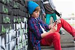 Boy Sitting and using a Tablet PC Outdoors, Mannheim, Baden-Wurttemberg, Germany