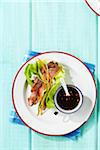 Overhead View of Meat in Lettuce Wrap with Sauce on the Side on Table