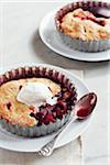 Tartelettes de prune avec crème glacée sur les plaques avec des cuillères