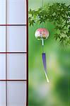 Wind chime and green maple leaves