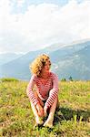 Woman sitting on rural hilltop