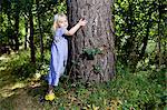 Mädchen knuddeln Baum im Wald