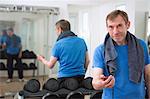 Trainer holding stopwatch in gym